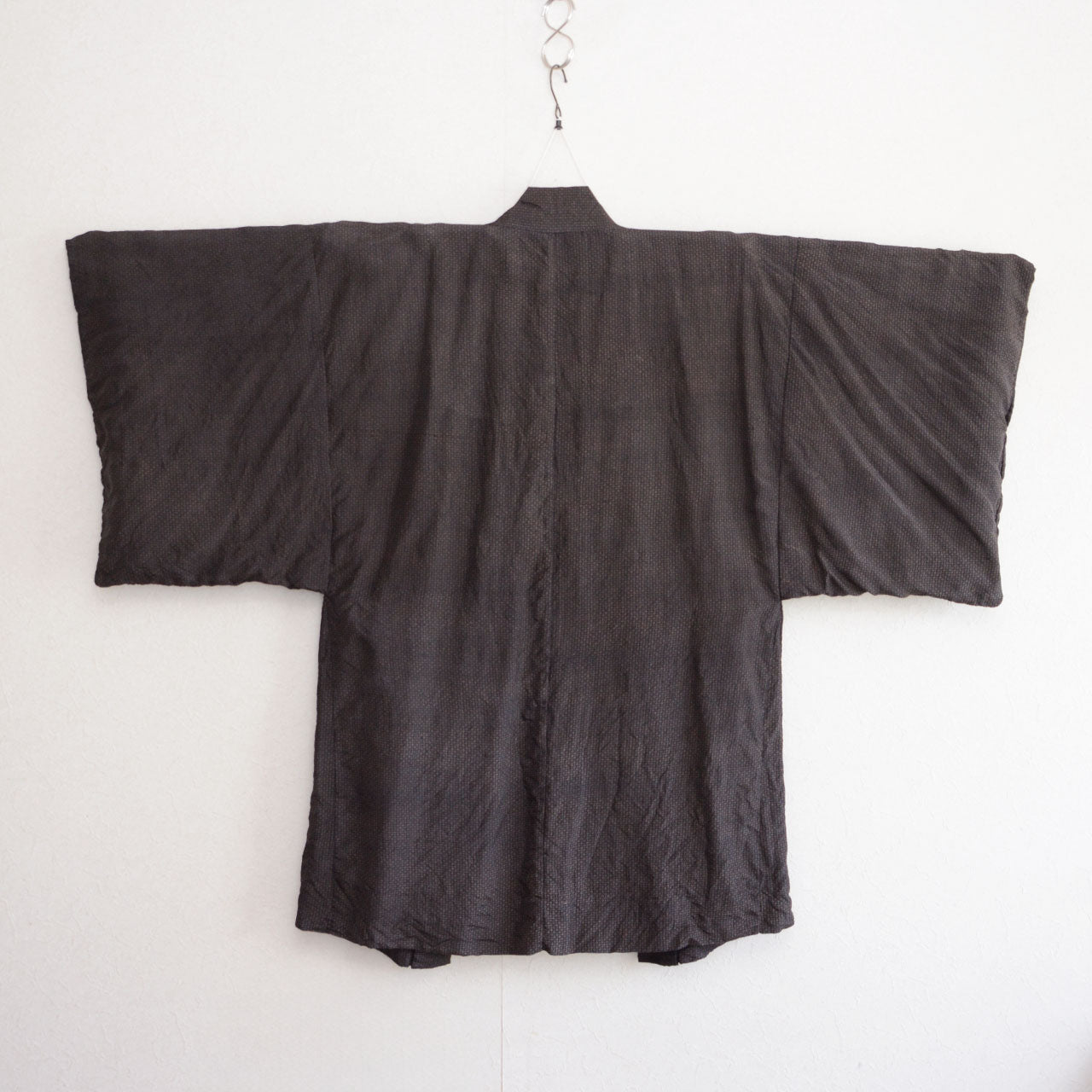 Vintage haori jacket, back view, on kimono hanger, dark silk blend, komon pattern, wide sleeve silhouette, Japan 1970s–80s