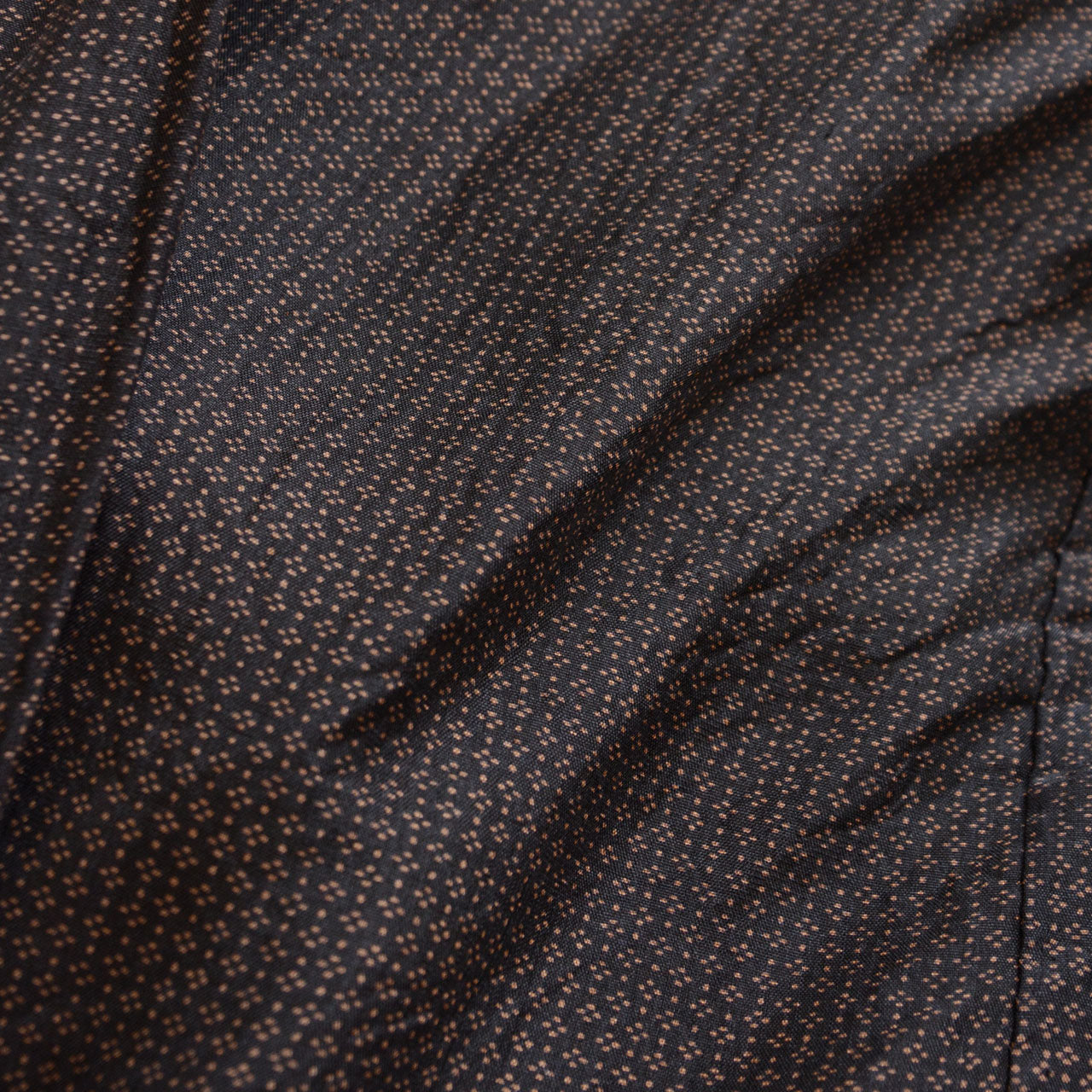 Close-up of komon fabric on vintage haori jacket, fine repeating pattern, dark silk blend with subtle luster, Japan vintage