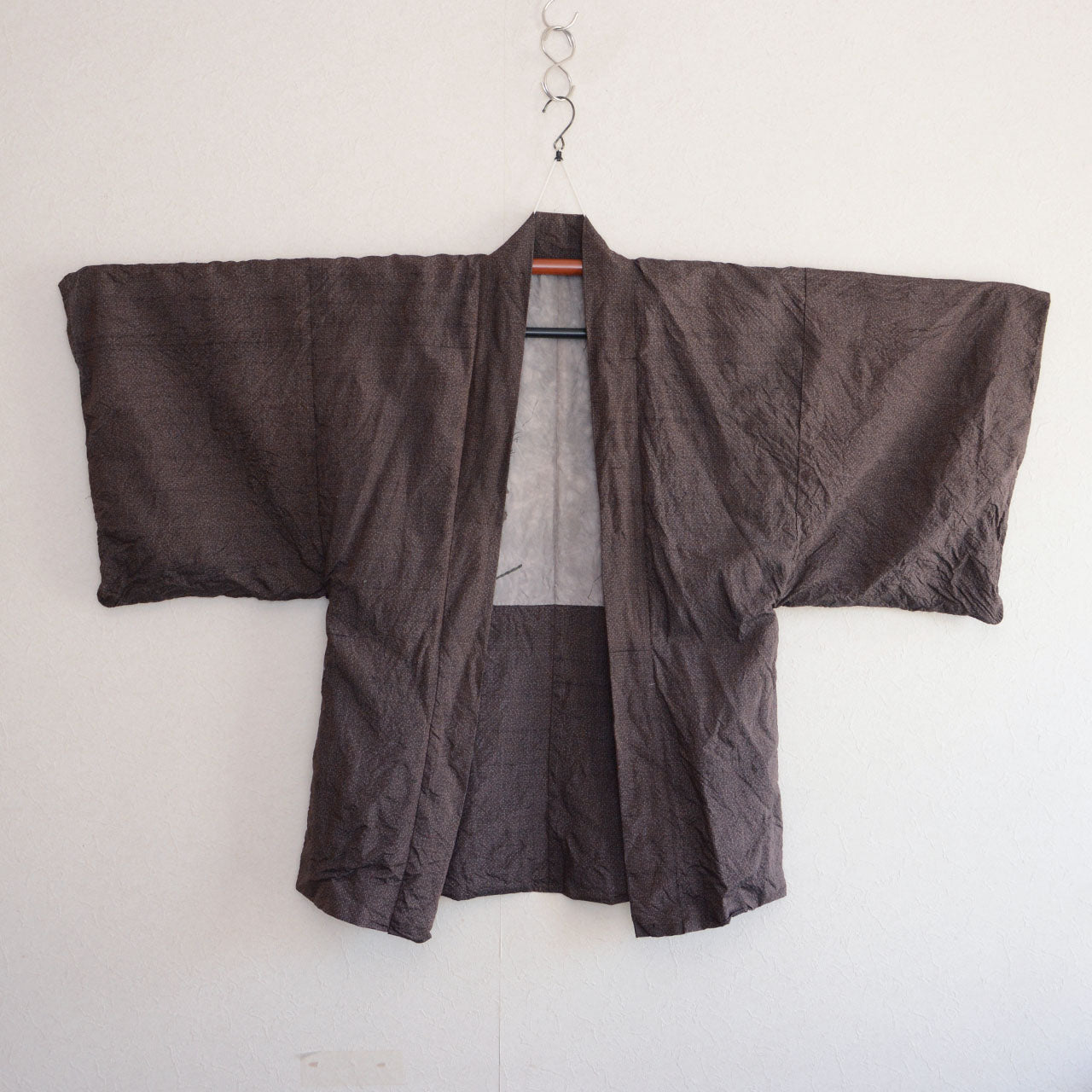 Men's vintage Japanese haori jacket in dark brown woven fabric — hanging view, open front silhouette, 1970s–1980s Japan