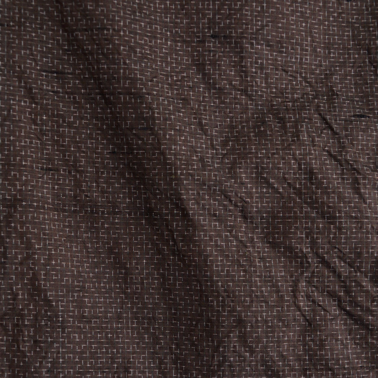 Close-up of dark brown woven fabric — geometric kasuri-style pattern, silk blend, vintage Japanese haori jacket