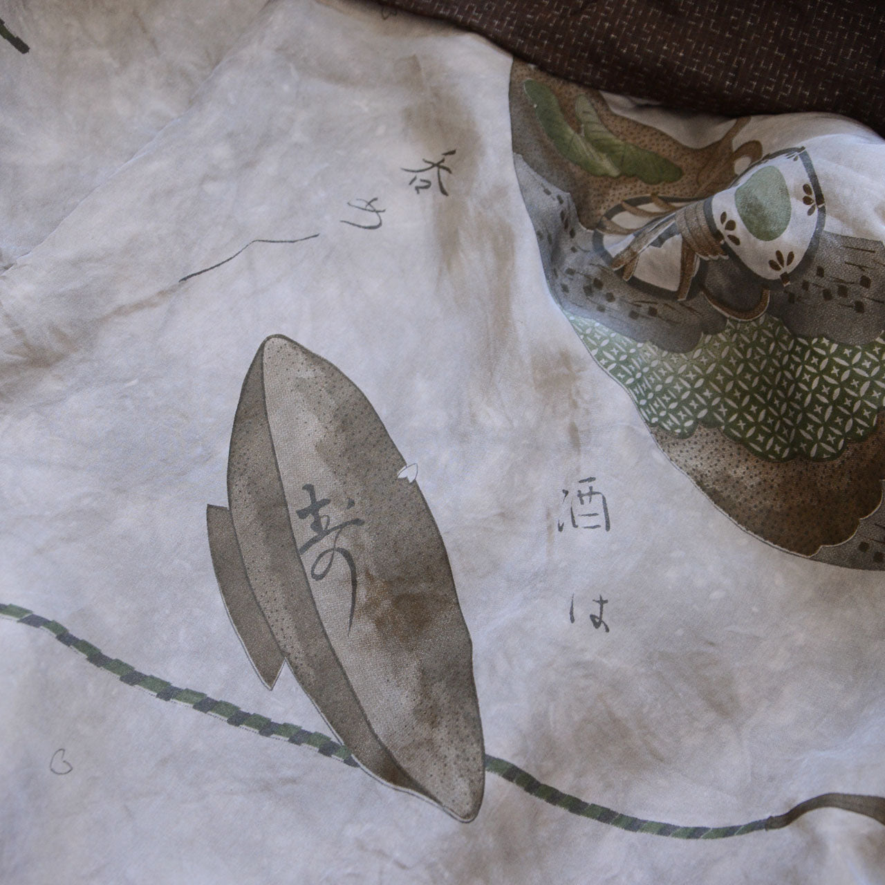 Close-up of haori lining — printed sake vessel and fan motifs with Kuroda Bushi lyrics "sake wa nome nome", vintage Japanese haori jacket