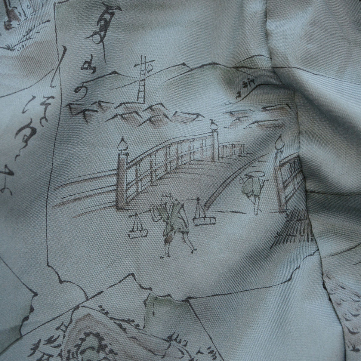 Vintage haori lining with a bridge, figures carrying loads and distant rooftops