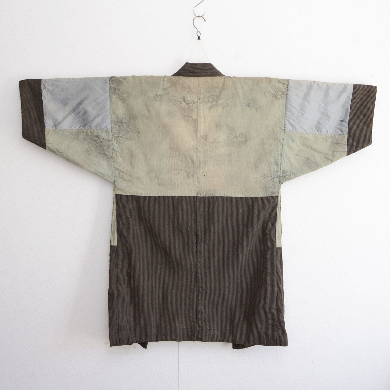 Striped cotton sleeve of a Japanese vintage haori jacket with fraying and missing stitches
