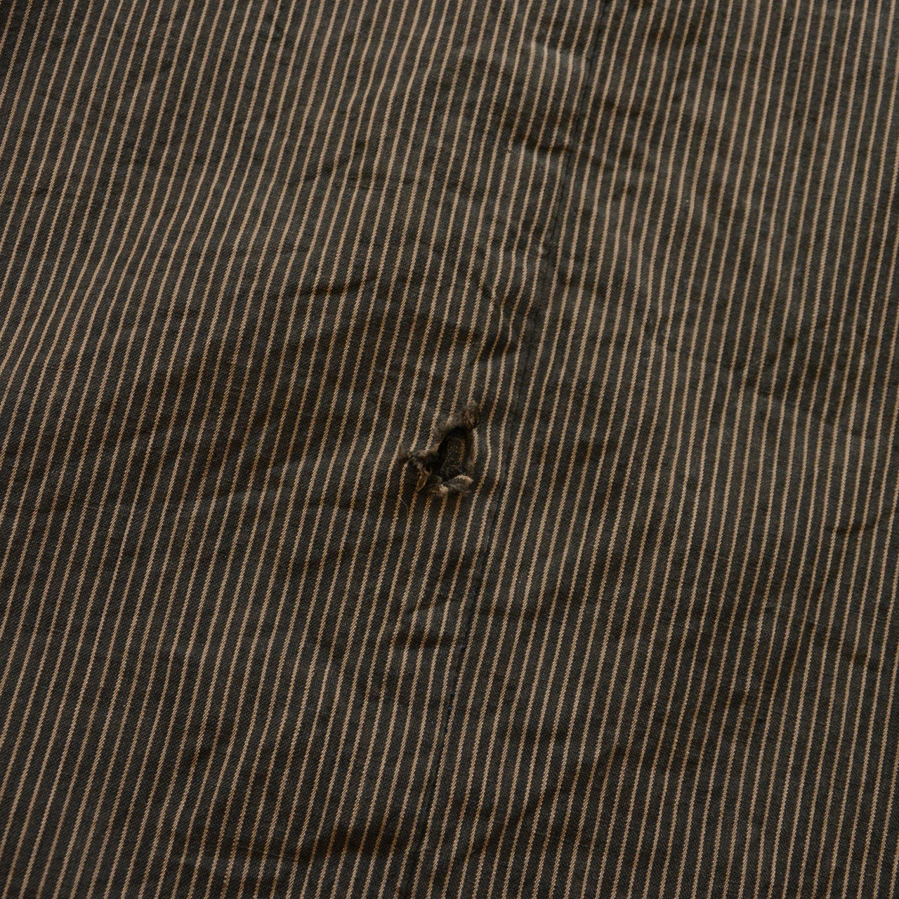Striped cotton outer fabric of a Japanese vintage haori jacket with abrasion and missing stitches