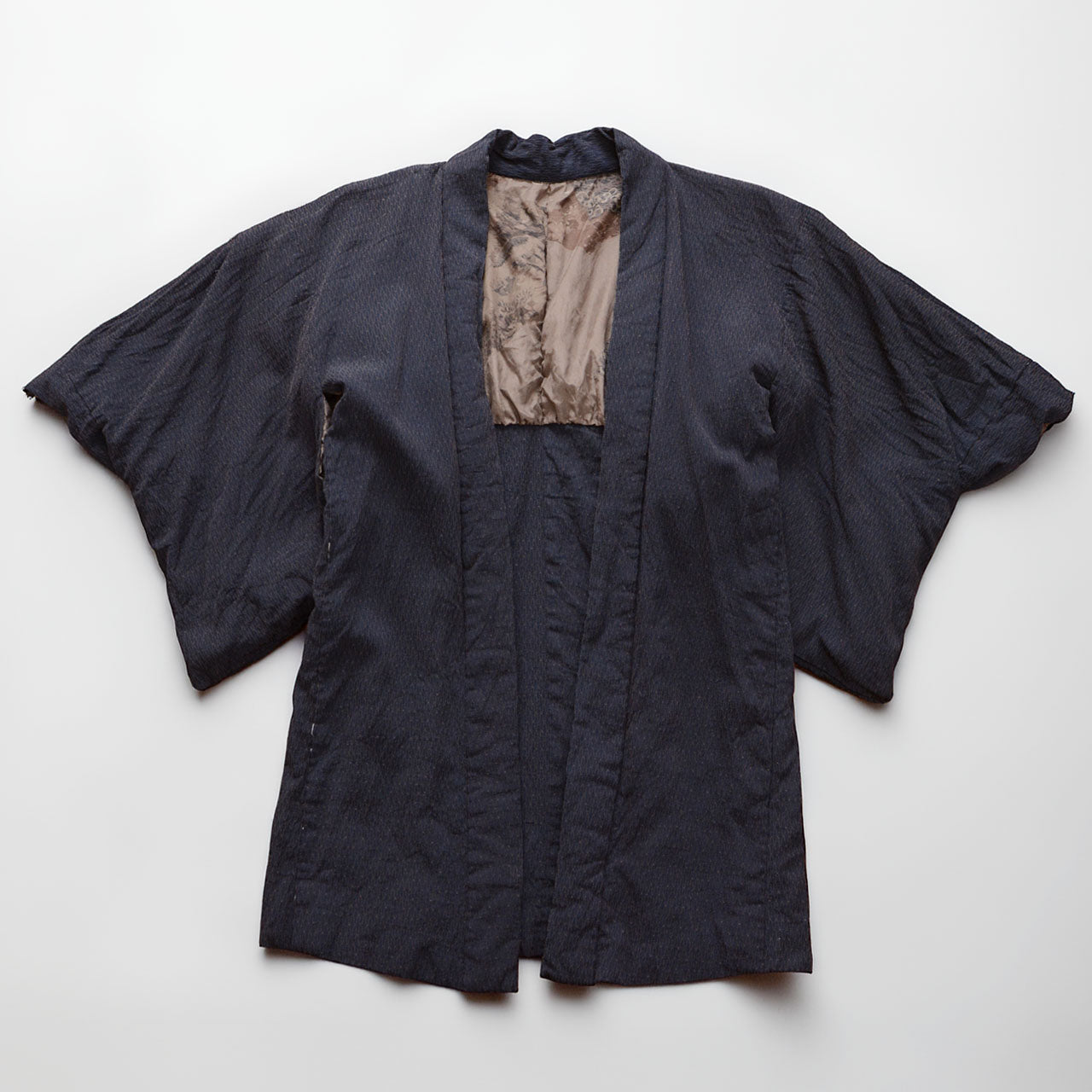Laid-flat view of a deep navy Japanese vintage haori kimono jacket with raised texture and scenic lining