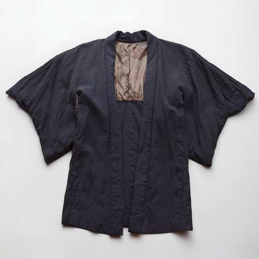 Laid-flat view of a deep navy Japanese vintage haori kimono jacket with raised texture and scenic lining