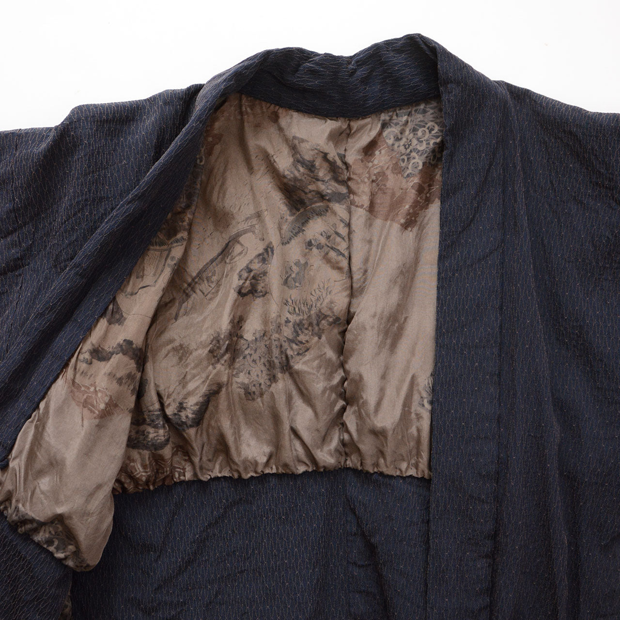 Interior of a deep navy Japanese vintage haori kimono jacket showing traditional scenic imagery on the lining