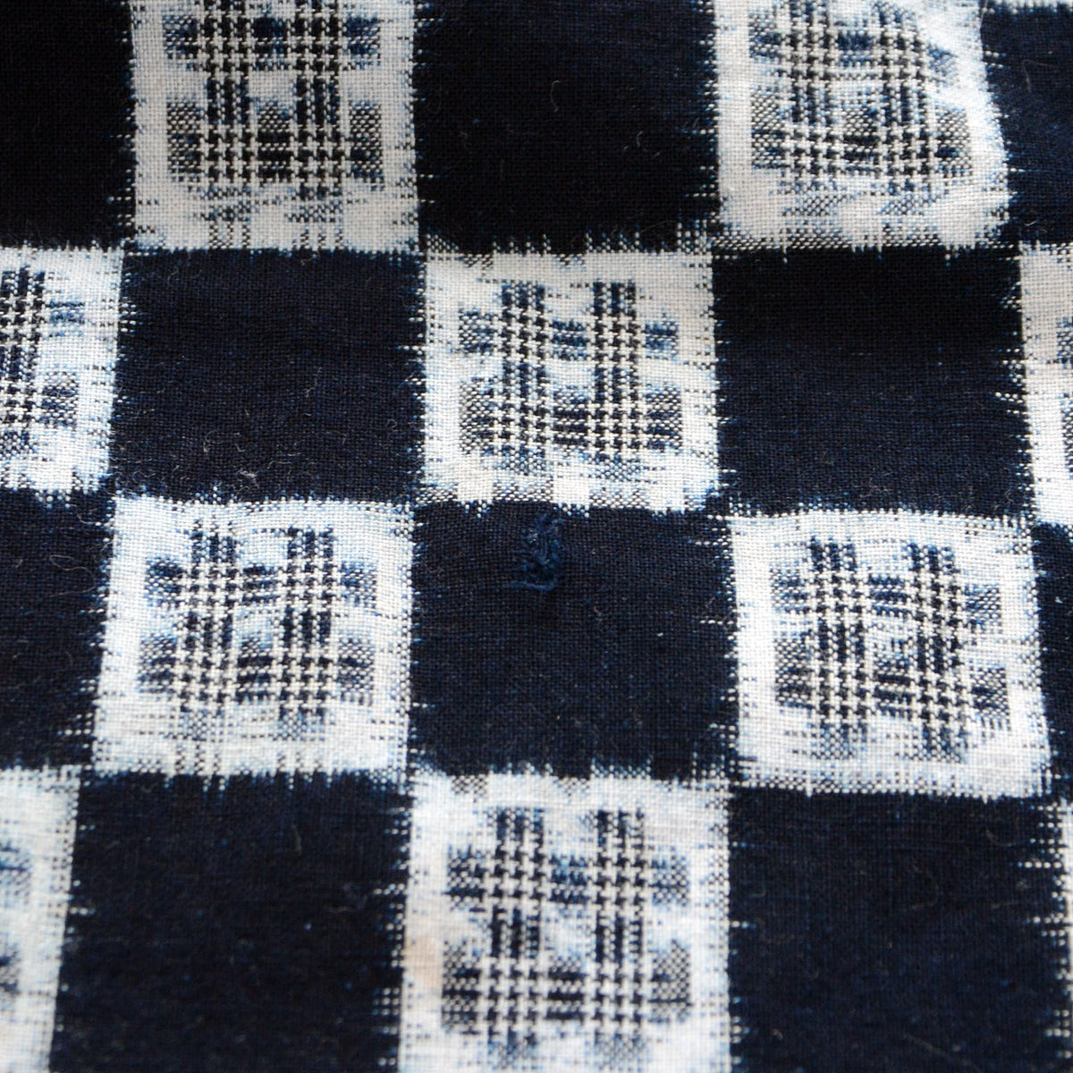 Indigo cotton checkered kasuri fabric with igeta motifs and a small damaged area