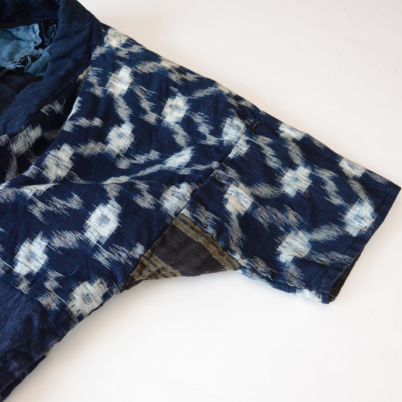 Japanese indigo textile art with coarse sashiko stitches and patchwork design.