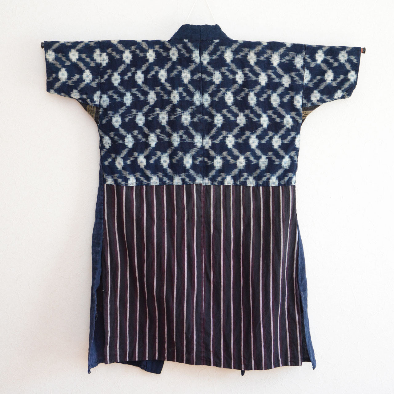Hand-stitched sashiko patterns connecting indigo-dyed fabrics in a noragi jacket.