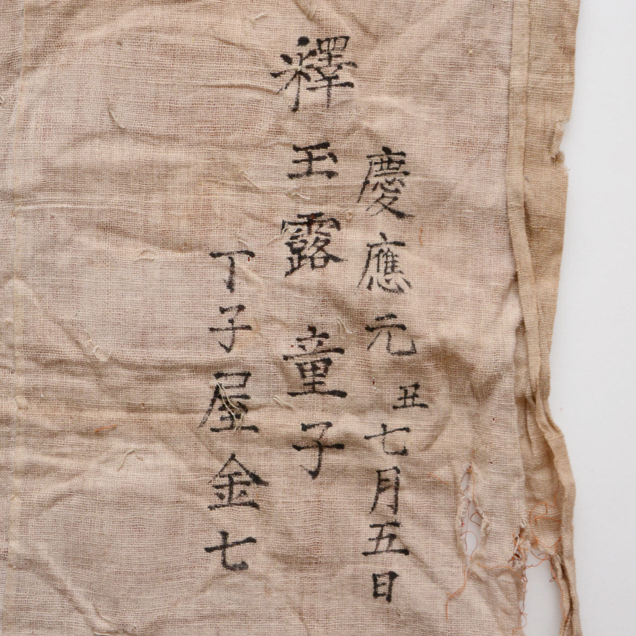 Historic Japanese textile featuring symbolic crest motifs and aged patina.