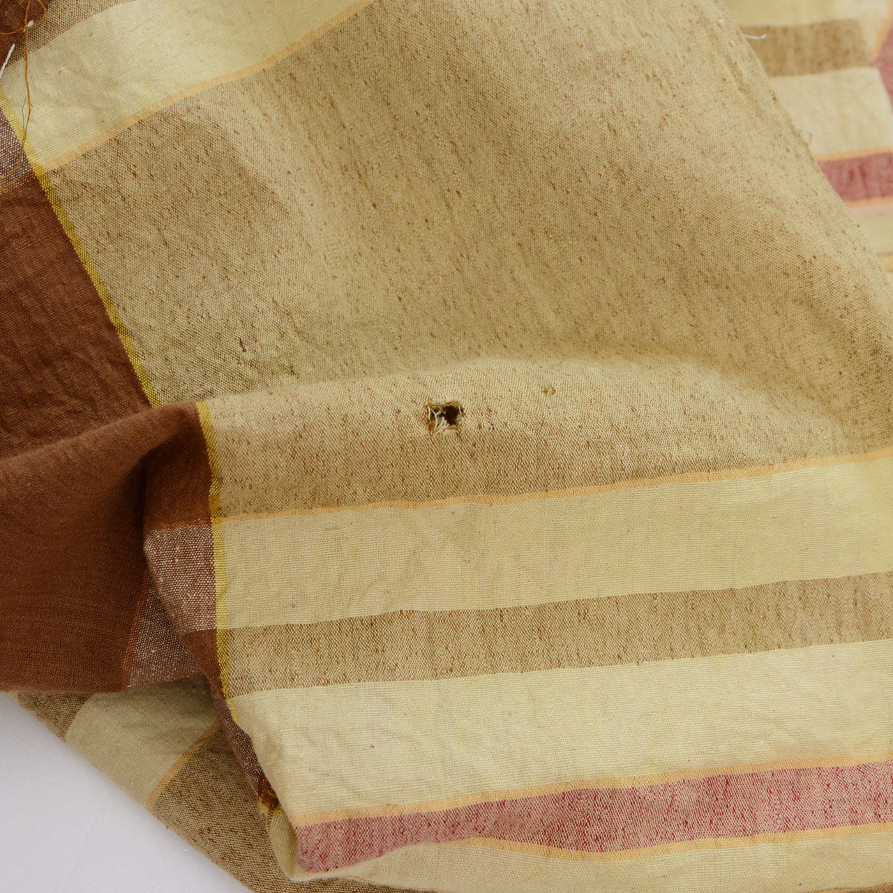 Hole in vintage Japanese cotton fabric — visible wear from decades of use