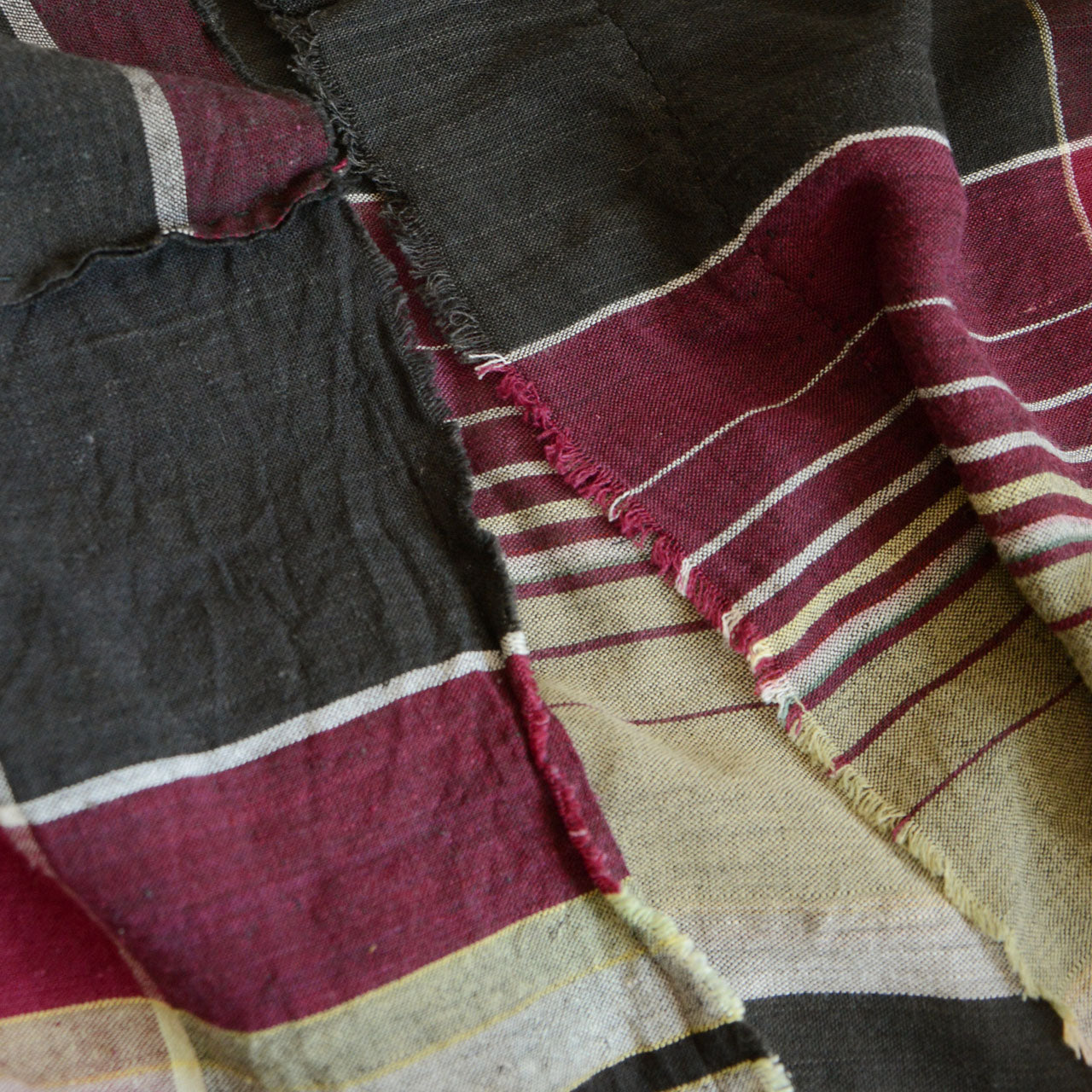 Unstitched Japanese vintage futon cover fabric showing wear, holes, and patch repairs