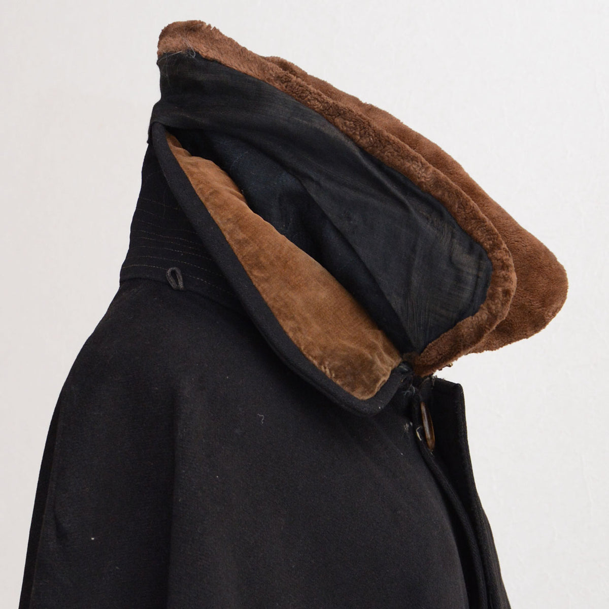 Partially opened brown fur collar revealing the original black velvet collar and attachment stitching.