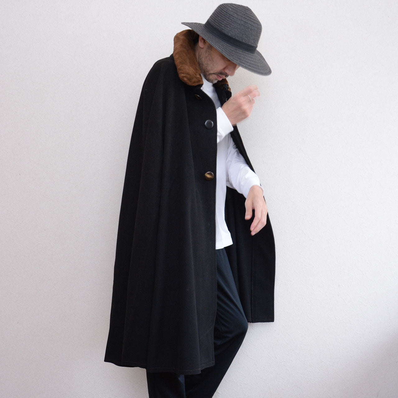 Model wearing a black Bankara mantle with brown fur collar and mismatched front buttons.