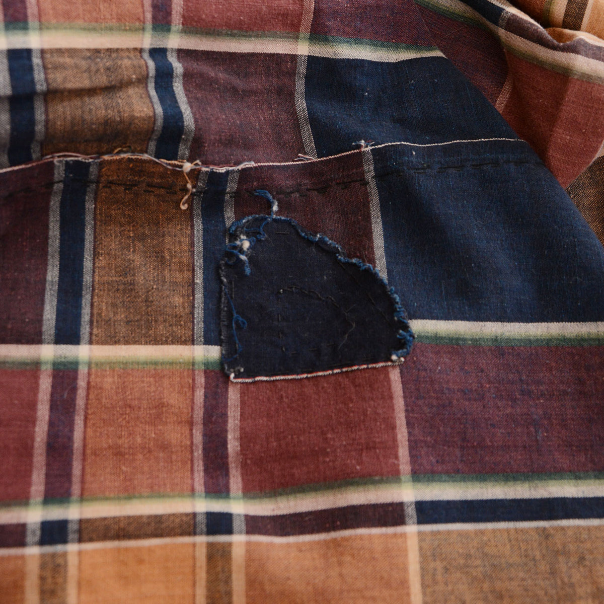 Indigo patch repair on brown and indigo checkered Japanese vintage cotton fabric