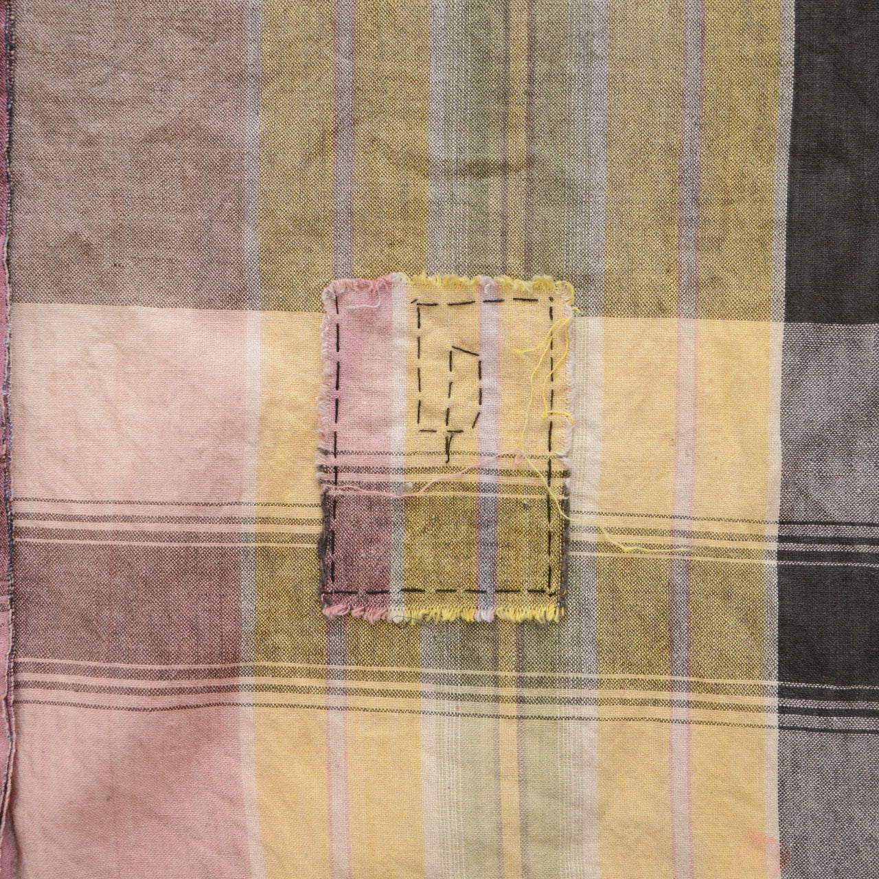 Japanese vintage cotton plaid fabric, hand-sewn boro repair patch close-up, Showa era mending