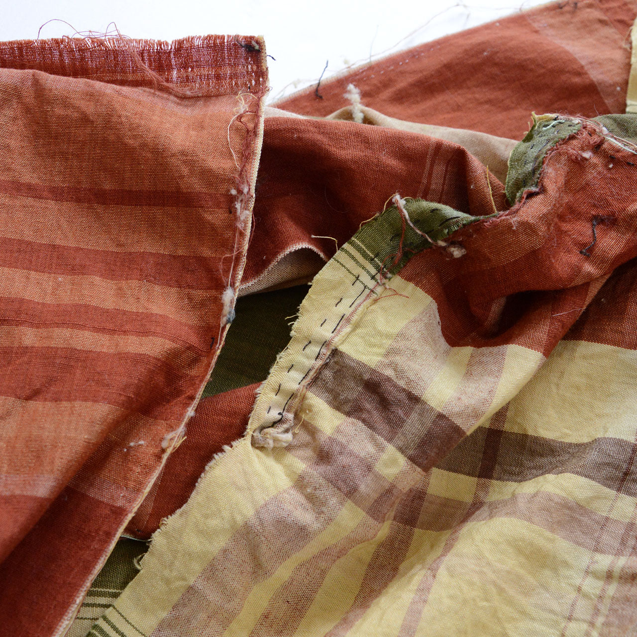 Japanese vintage cotton fabric, olive green plaid with seam detail, unstitched Showa-era futon textile, needle holes and residual threads along stitching line