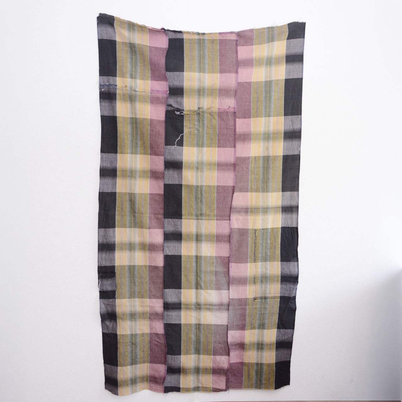 Full back view of vintage Japanese cotton fabric, displayed on wall — plaid pattern in dusty pink, charcoal, and khaki