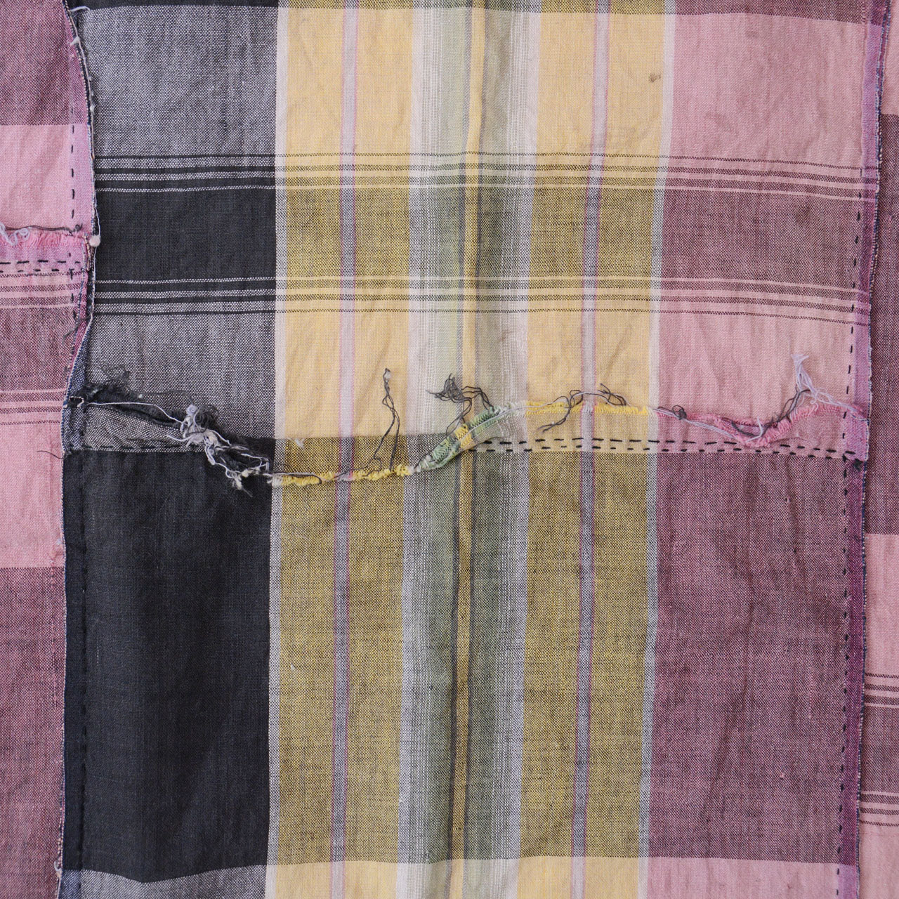 Patched seam on vintage Japanese cotton fabric — hand-sewn repair joining two sections of cloth