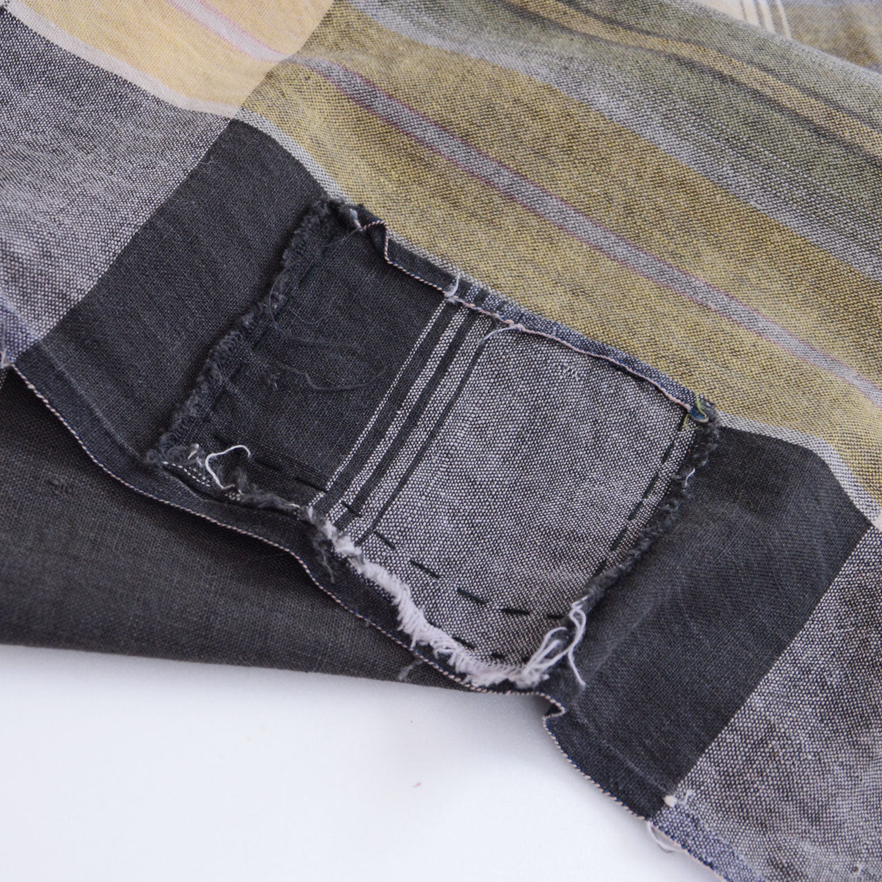 Boro patch repair on vintage Japanese cotton fabric — applied fabric piece hand-stitched over worn area, authentic boro textile technique