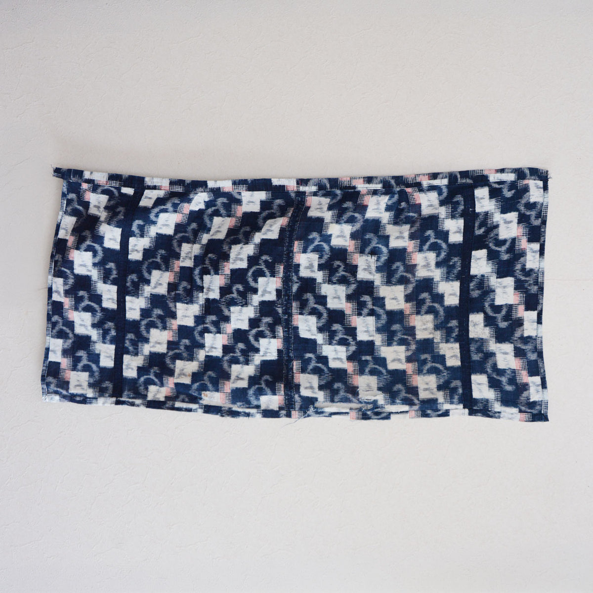Mid-Showa indigo cotton fabric with white and red kasuri motifs, a central seam and frayed fabric edges