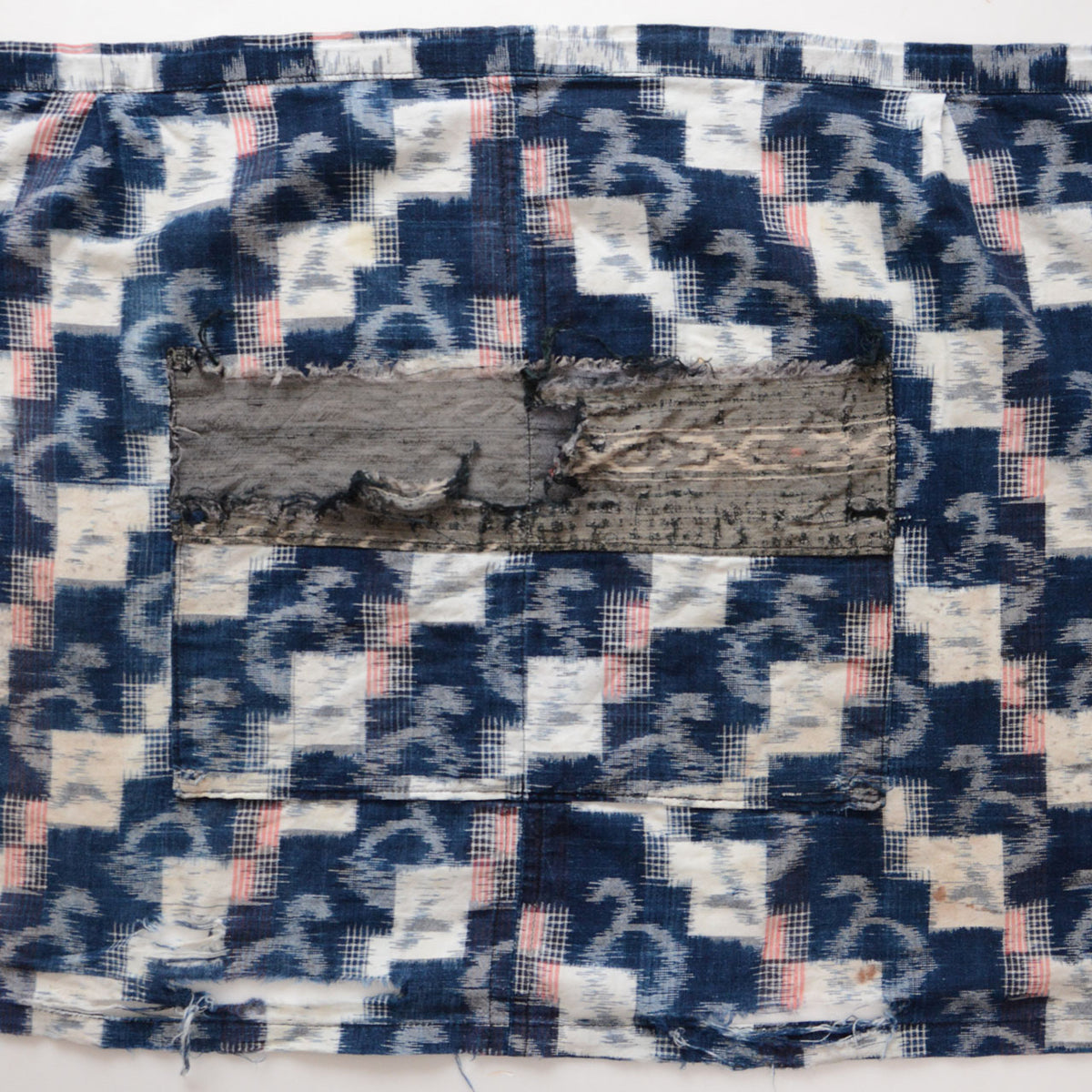 Japanese vintage indigo kasuri cotton textile with missing pocket fabric, fraying and damaged fabric edges