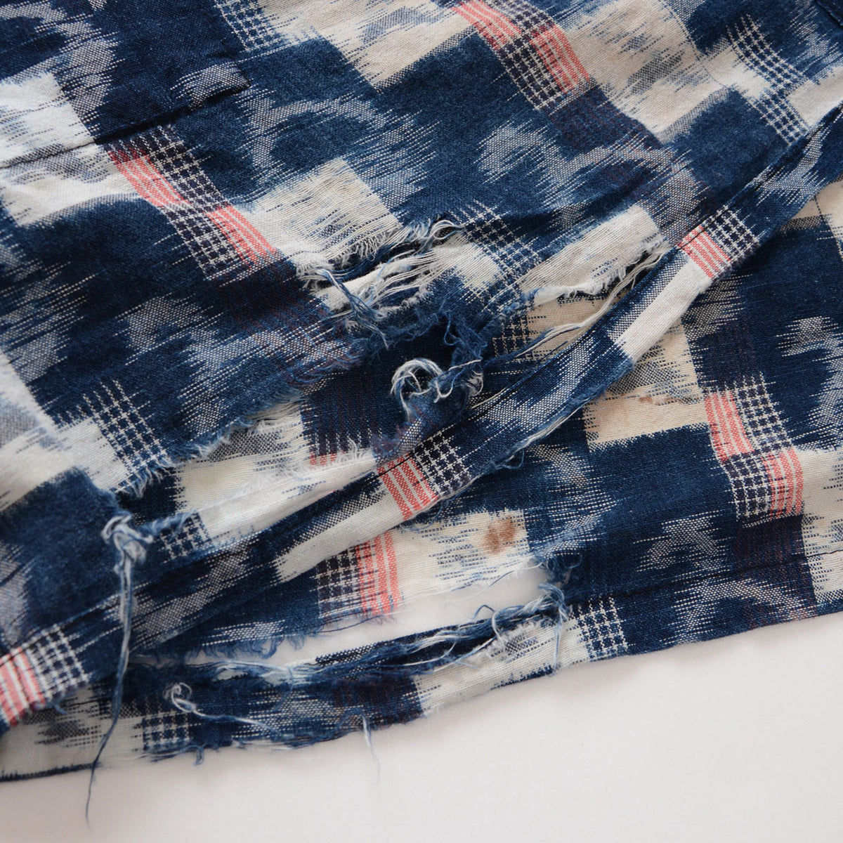 Mid-Showa indigo cotton fabric with white and red kasuri motifs, multiple tears and loose threads