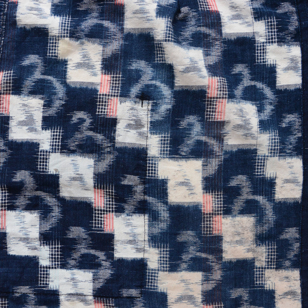 Mid-Showa Japanese indigo cotton textile with white angular and curved kasuri motifs and fine red lines
