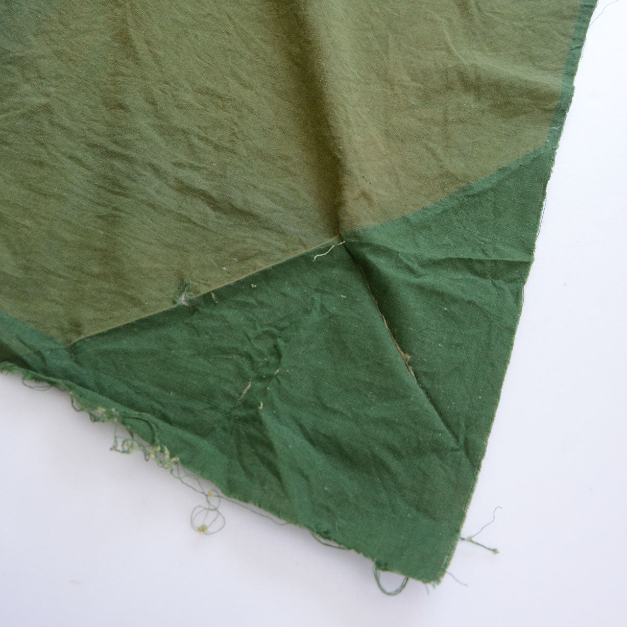 Showa-era Japanese vintage cotton fabric, solid moss green, striking contrast between heavily faded and unfaded sections, natural aging, antique Japanese cotton
