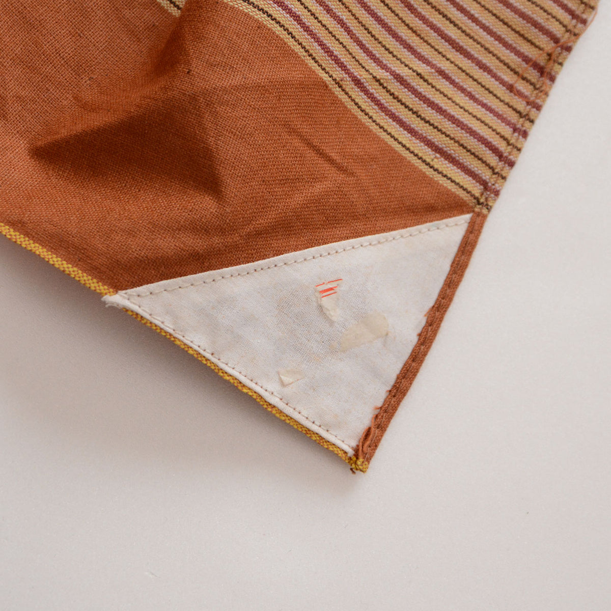 White name cloth at the corner of a vintage cotton furoshiki with remnants of a presumed price sticker