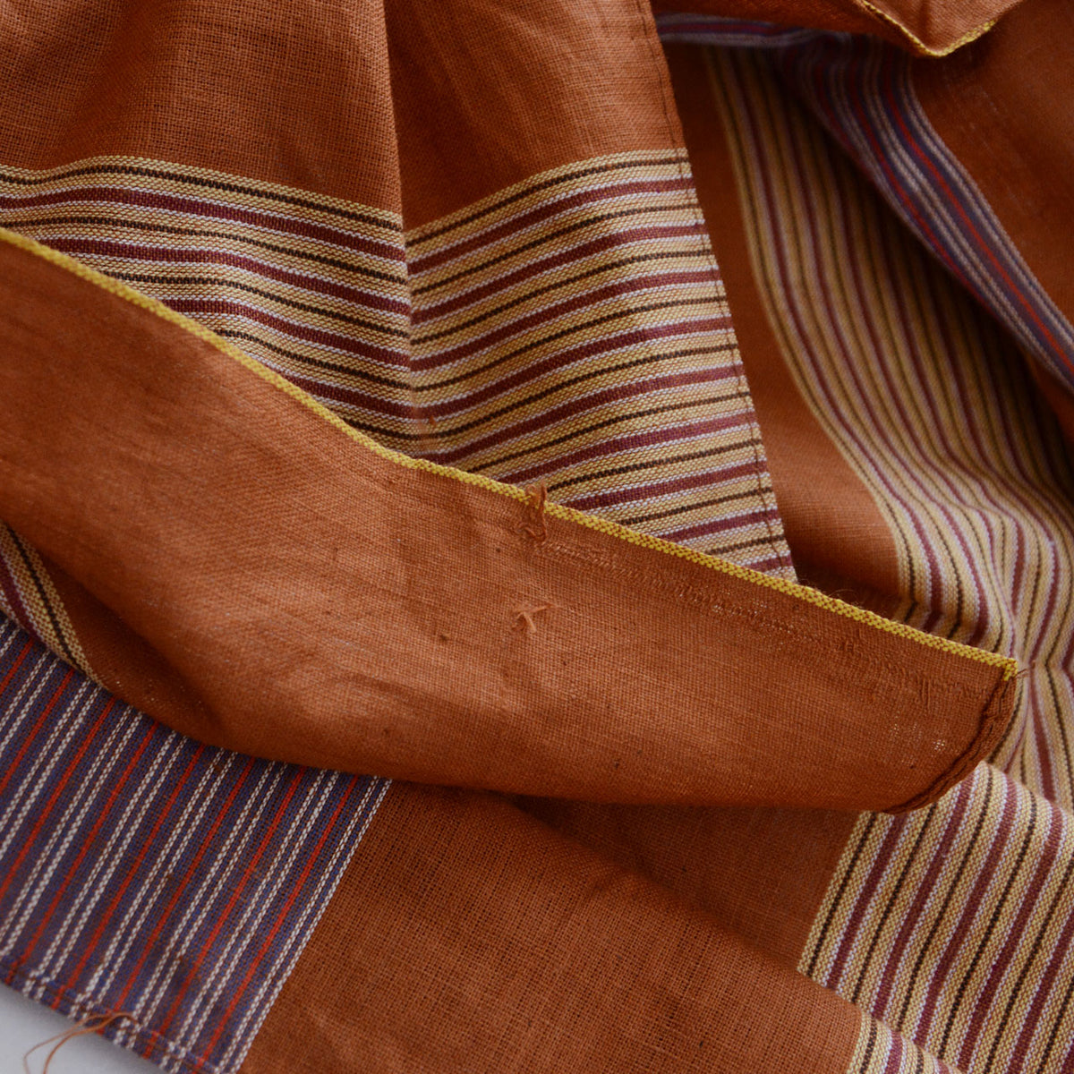 Fraying threads near the edge of a brown striped cotton furoshiki
