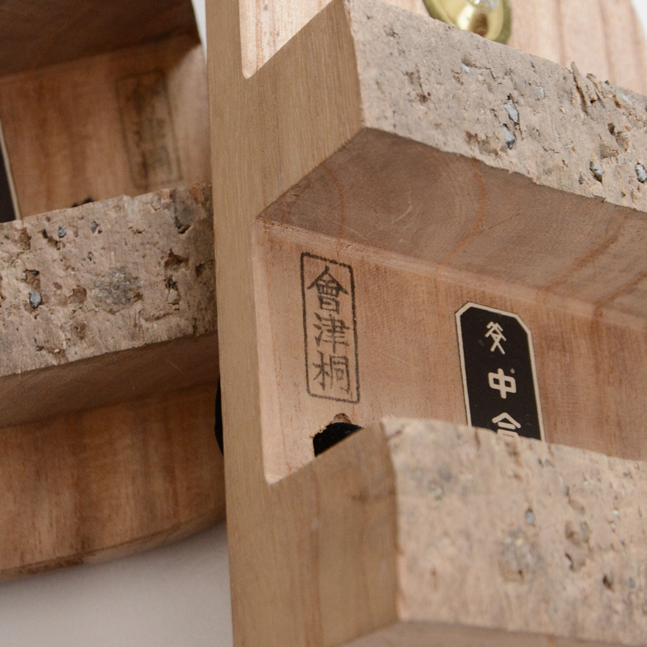 Close-up of engraved Aizu Kiri (會津桐) brand plaque on the wooden tooth of the geta sandal