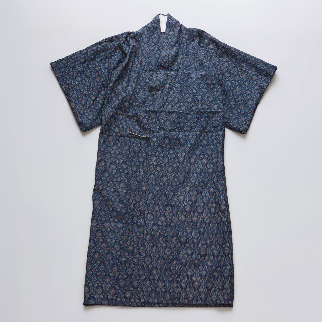 Full view of a navy patterned kimono spread against a white background