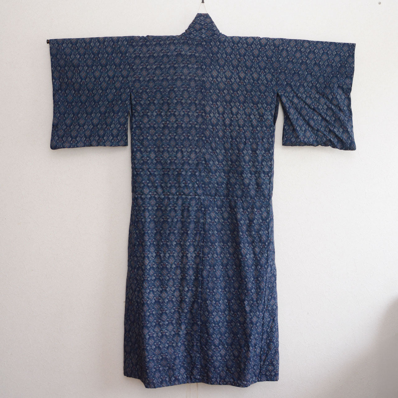 Back view of a navy patterned kimono with the sleeves spread out