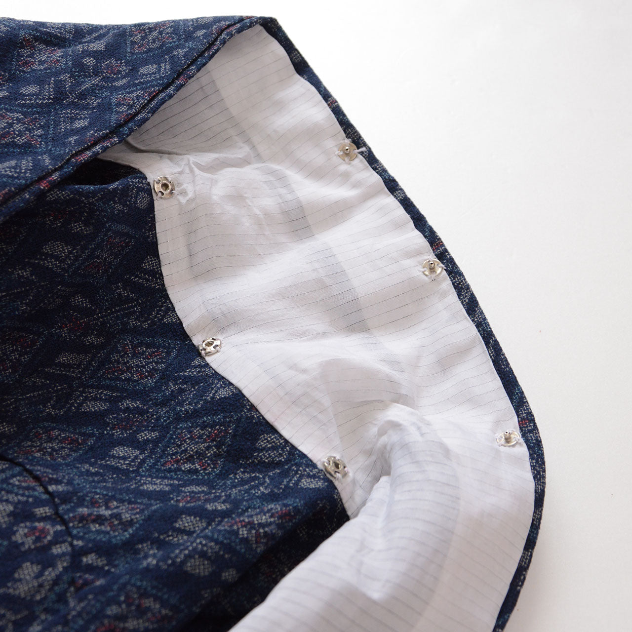 White lining and multiple snap buttons inside the wide collar of a kimono
