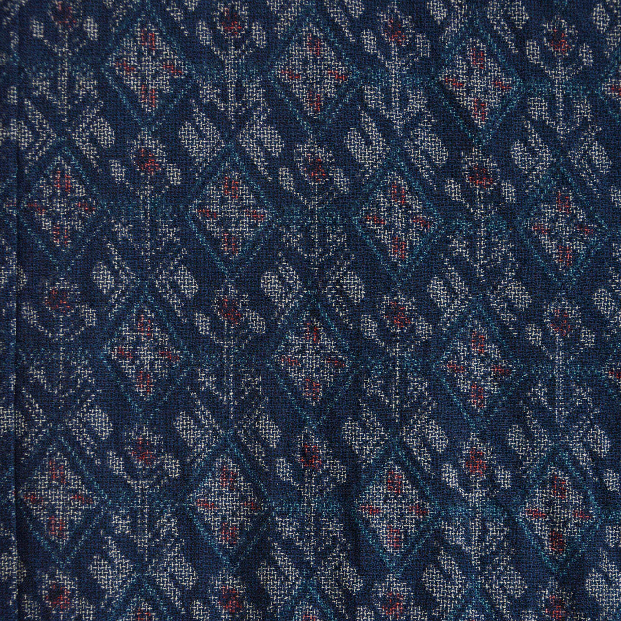 Close-up of the kimono pattern with light blue, white, and red motifs on a navy ground