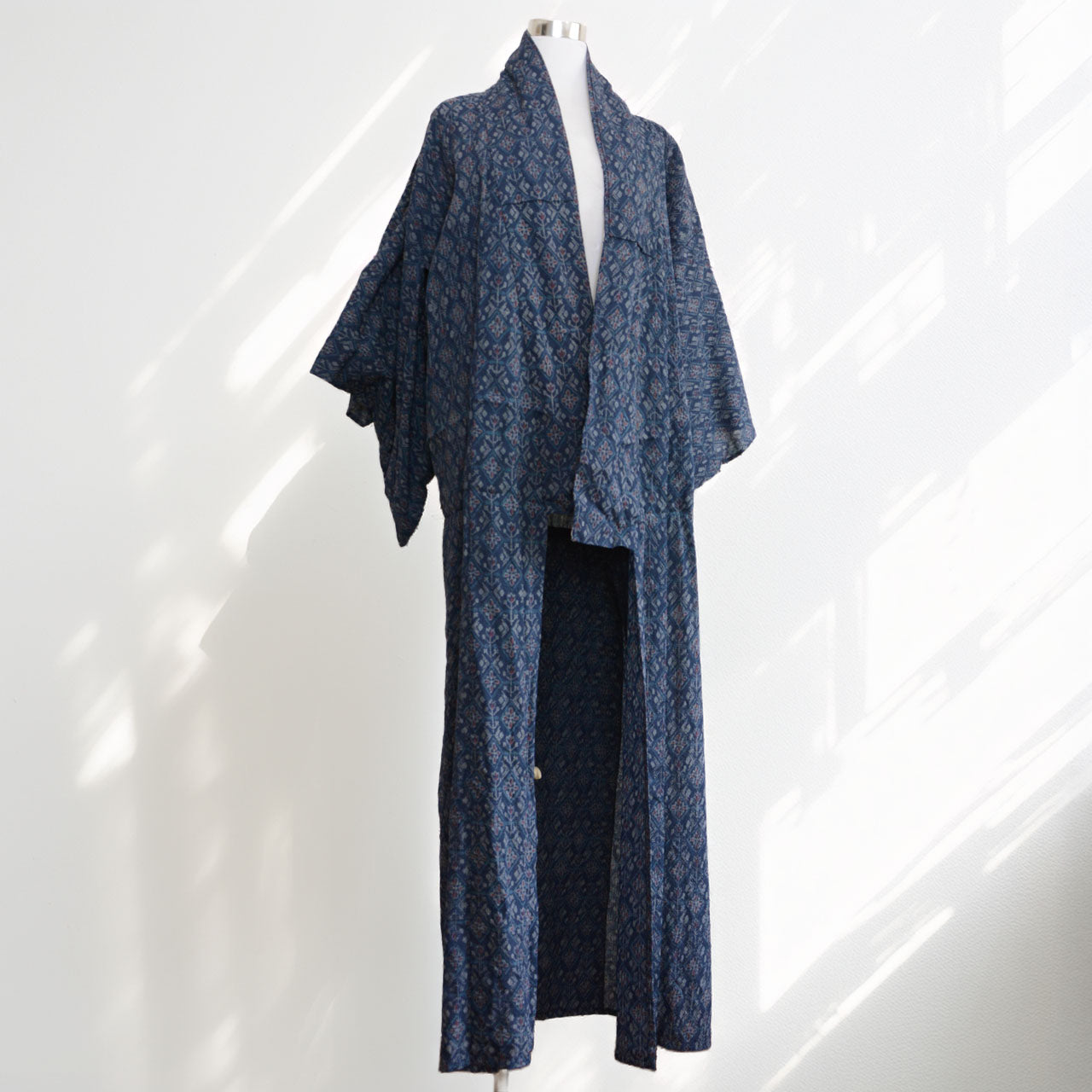 Navy patterned kimono displayed open on a dress form