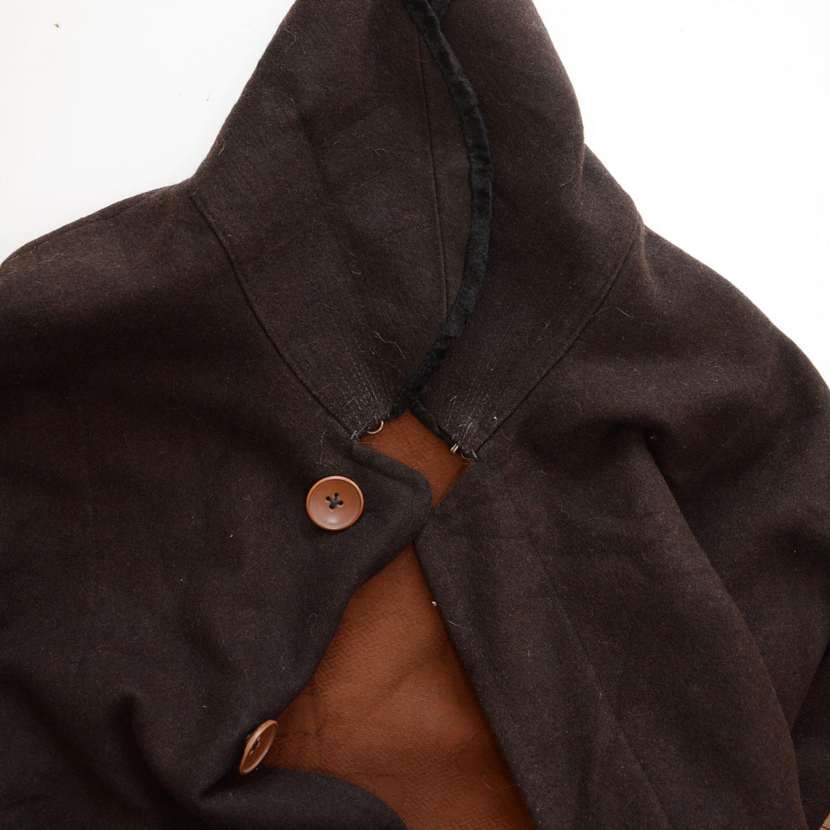 Brown fabric beneath the collar and neckline fastenings on a vintage mantle