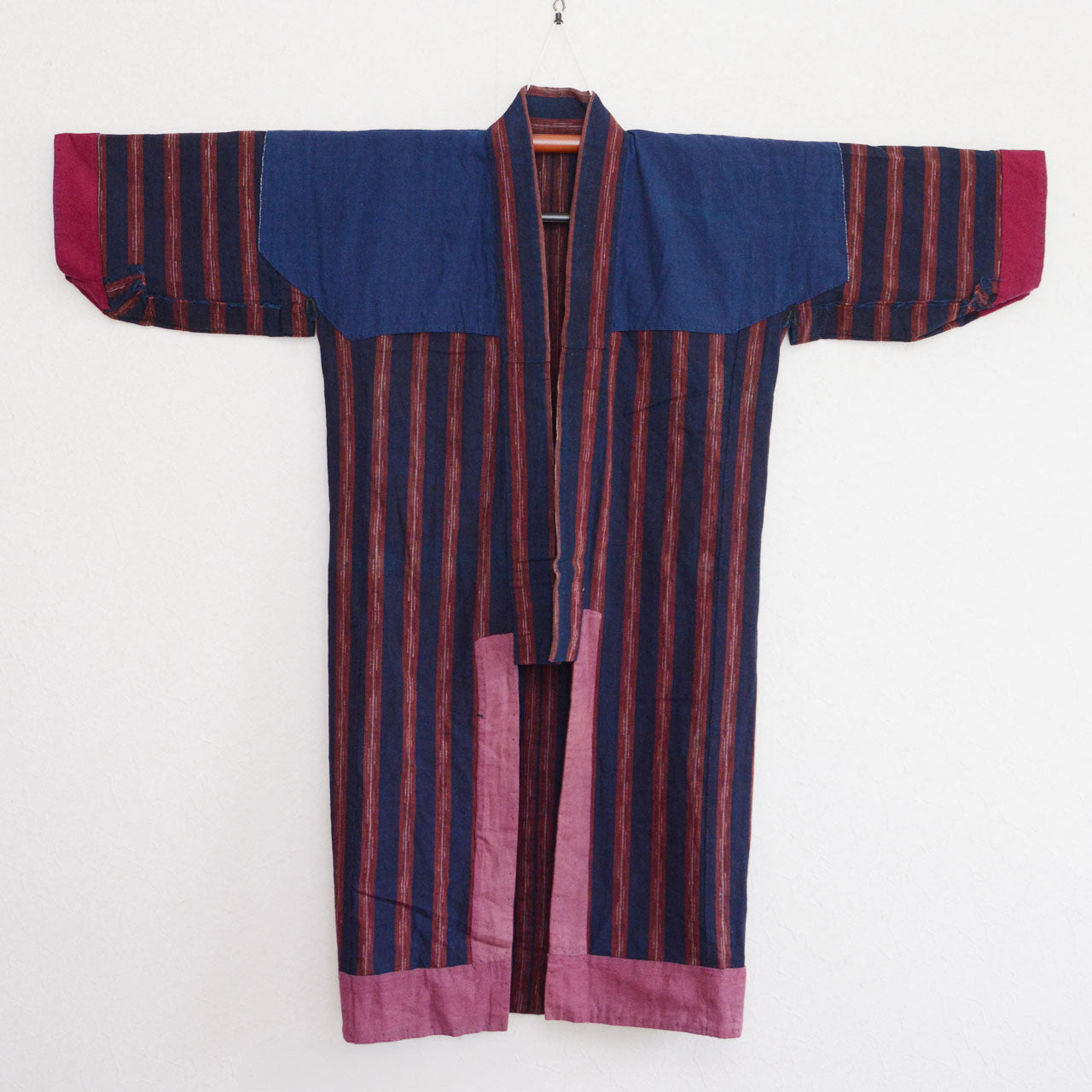 Vintage noragi jacket on hanger, front view of lining — plain indigo cotton, handmade construction, Tohoku, early Showa era