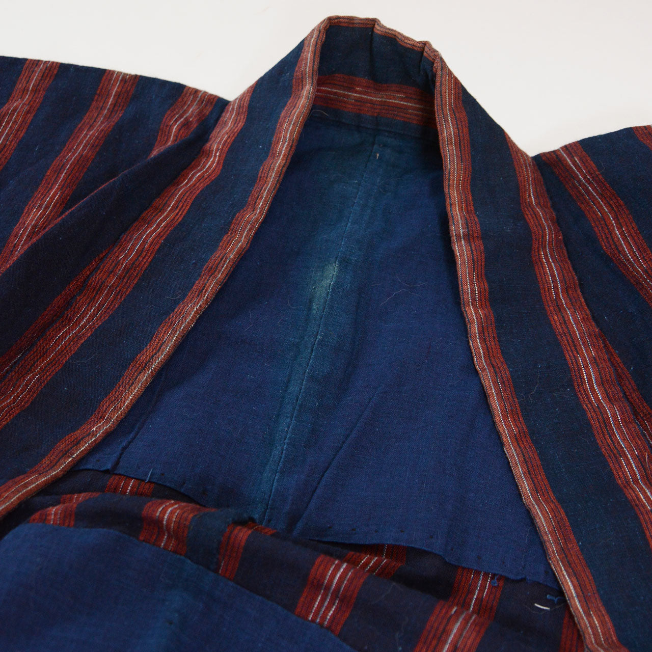 Plain indigo cotton lining of a vintage noragi — quiet and honest against the bold exterior stripe, early Showa era