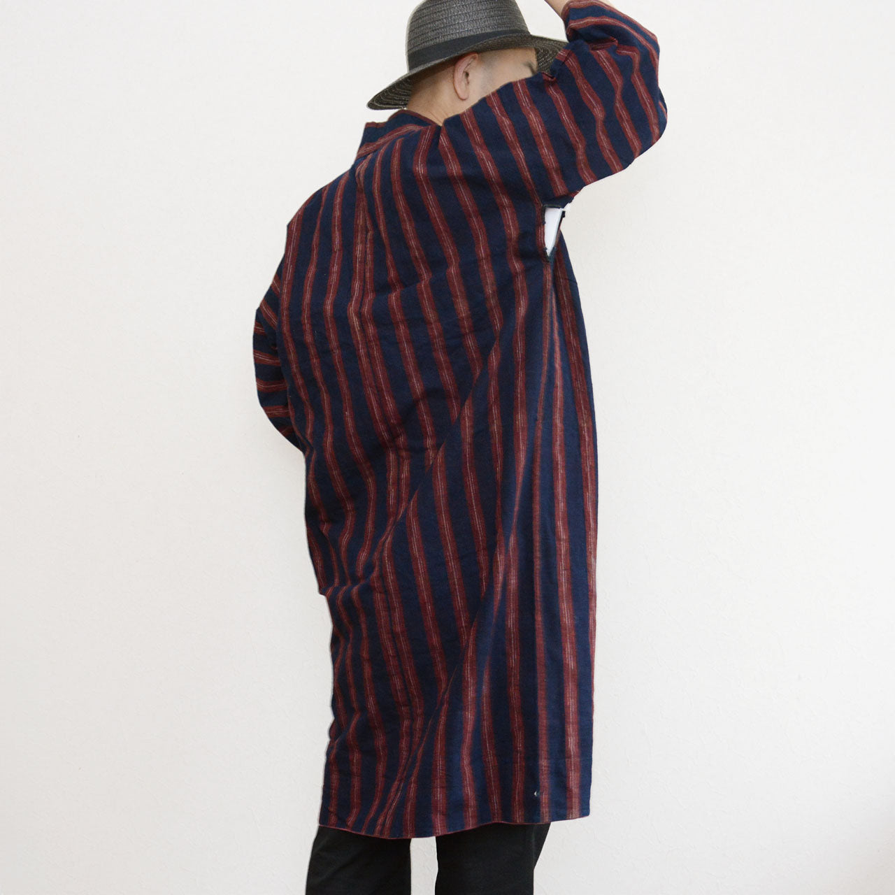 Vintage Japanese noragi jacket worn by a male model, back view — indigo-dyed cotton with bold red stripe, full length silhouette, Tohoku, early Showa era