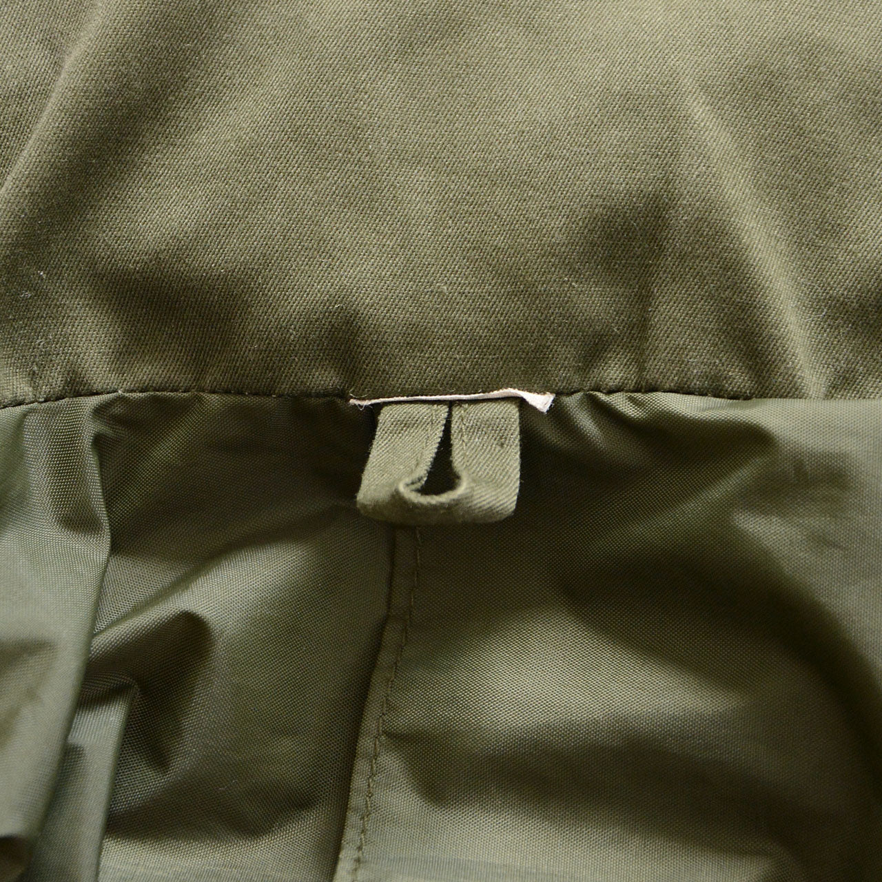 Olive drab military jacket with zip-up closure
