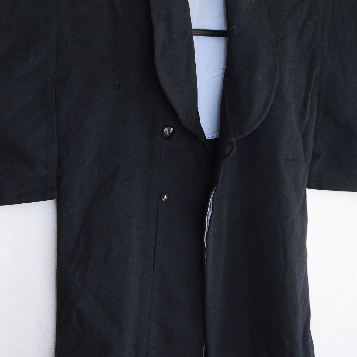 Shawl collar and front fastenings of a black wool Japanese vintage kimono coat