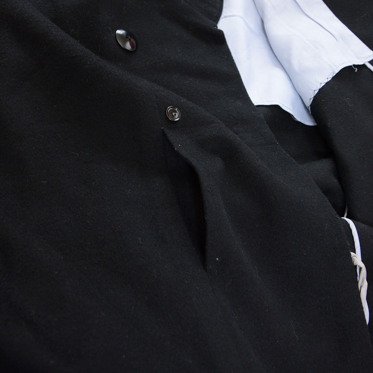 Slit pocket and front fastenings of a black wool Japanese vintage kimono coat