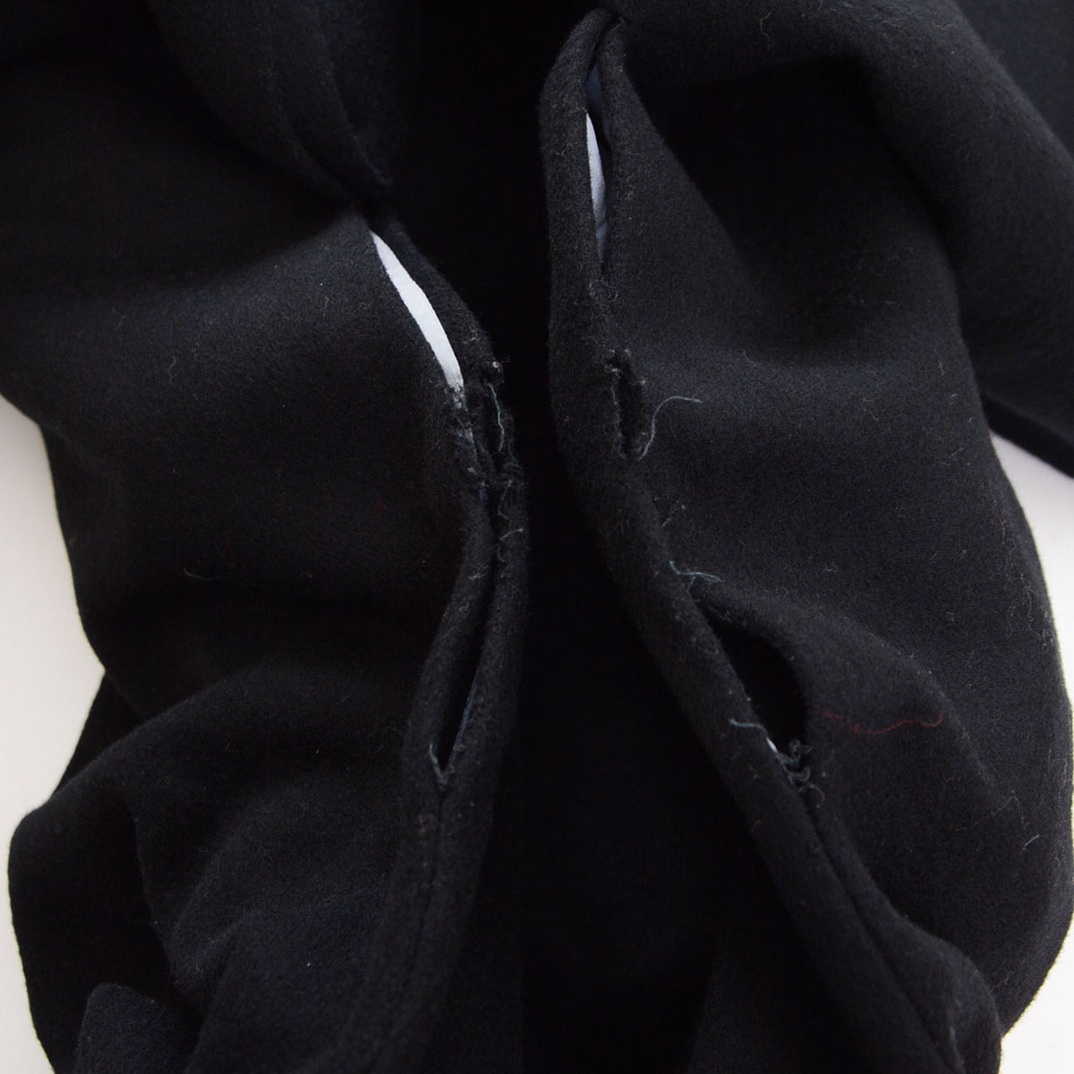 Damage at the Miyatsuguchi underarm openings of a black wool Japanese vintage kimono coat