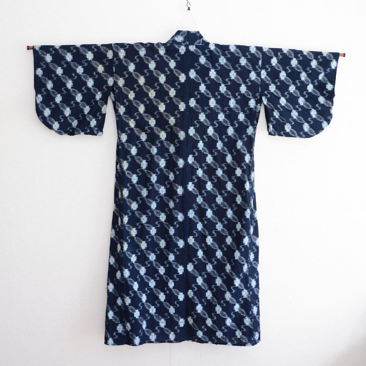Back view of a Japanese vintage indigo kasuri cotton kimono robe on a hanger