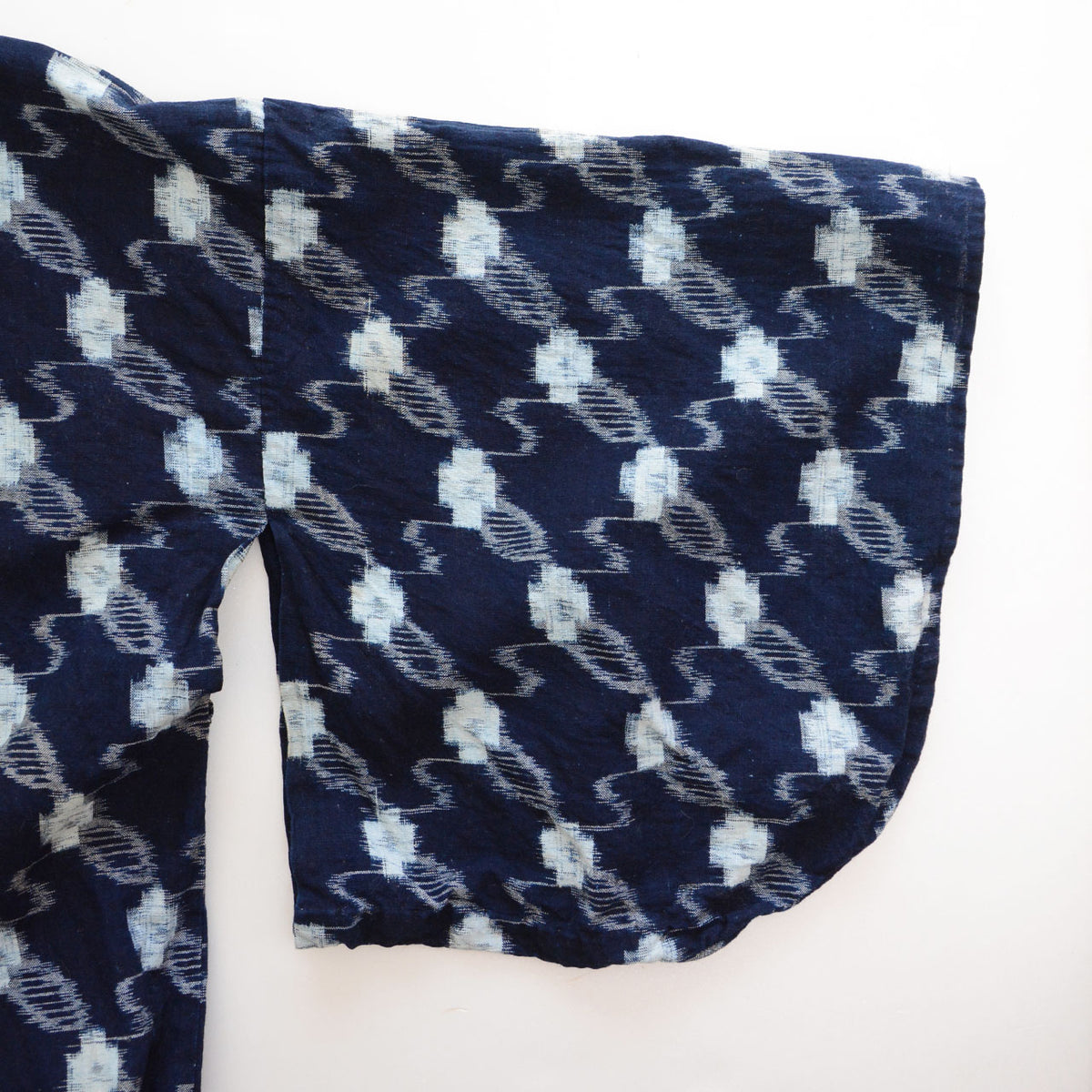 Close-up of the sleeve of an indigo kasuri cotton kimono robe showing its white kasuri pattern