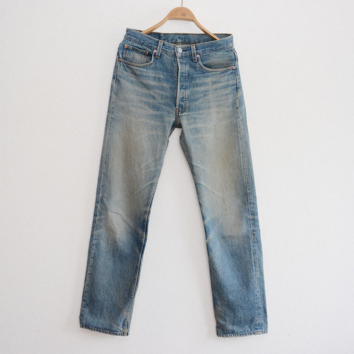 Vintage Levi’s 501 jeans in faded blue denim with whiskering and darker blue lower legs