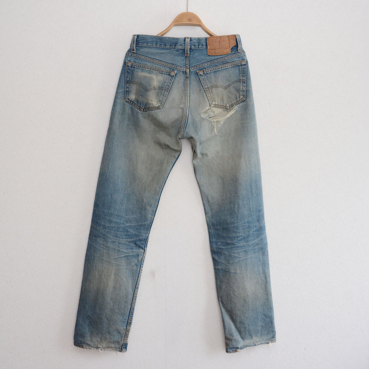 Vintage Levi’s 501 jeans with faded denim, arcuate pocket stitching and fraying below the right rear pocket
